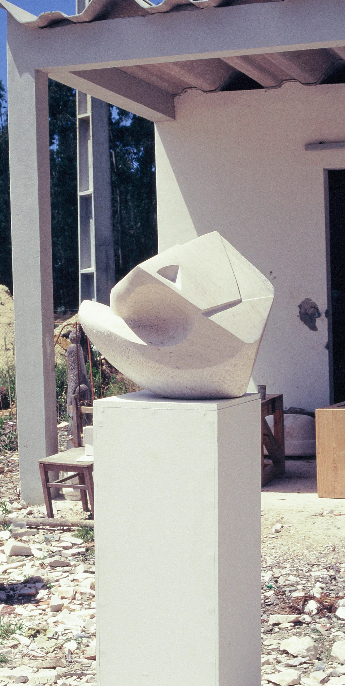 Escultura abstracta branca de Araújo Pinto sobre pedestal.
